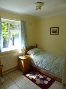 a bedroom with a bed and a window at Sea view bungalow in The Mumbles