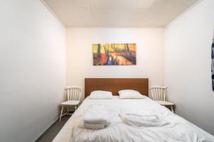 Casa Elise في ويستوتر: غرفة نوم بيضاء مع سرير مع كرسيين