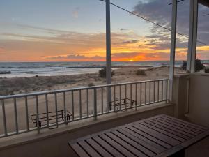 - un balcon avec vue sur la plage au coucher du soleil dans l'établissement Veranda sul mare di Donnalucata, à Donnalucata