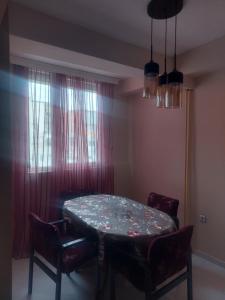 a dining room with a table and chairs and a window at Hana's Luxury apartment in Skopje