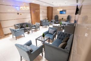 a waiting room with couches and tables and chairs at Lamar Ajyad First Hotel Tower B in Mecca