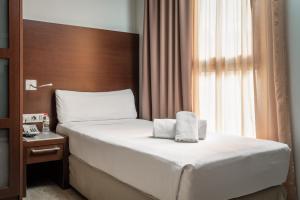 a hotel room with a bed and a window at Hotel Madanis Liceo in Hospitalet de Llobregat