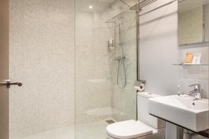 a bathroom with a shower and a toilet and a sink at Hotel Madanis Liceo in Hospitalet de Llobregat