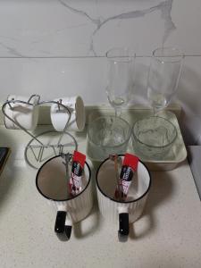 three empty glasses and bowls sitting on a counter at Shanghai Garden Apartment - Near Downtown Wukang Road in Shanghai