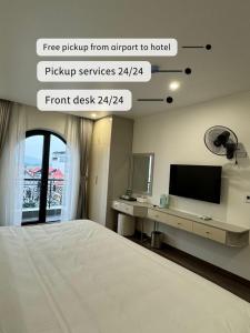 1 dormitorio con 1 cama y escritorio con TV en Grand Dragon Noi Bai Hotel en Hanoi