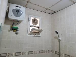 uma casa de banho com um chuveiro, uma ventoinha e uma janela. em NICE APARTMENT em Kituoni