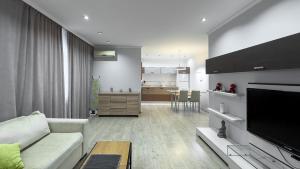 a living room with a white couch and a kitchen at Damaris Apartments 2 in Chişinău