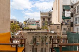 einen Balkon mit Stühlen und Stadtblick in der Unterkunft Studio with sunny balcony in Exarcheia in Athen