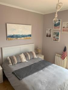 une chambre avec un lit et un tableau au mur dans l'établissement Vistas al mar, amplia terraza y garaje, à Miengo