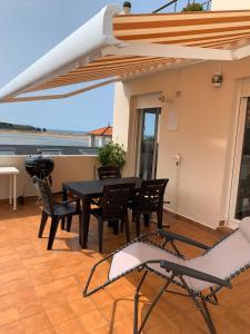 un patio avec une table, des chaises et un barbecue dans l'établissement Vistas al mar, amplia terraza y garaje, à Miengo