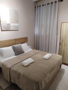 een slaapkamer met een groot bed en 2 handdoeken bij Pensión A&E in Manises