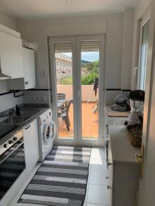 une cuisine avec une porte menant à une terrasse dans l'établissement Vistas al mar, amplia terraza y garaje, à Miengo