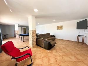 uma sala de estar com um sofá e uma mesa de bilhar em Villa Entrecolinas em São Bartolomeu de Messines