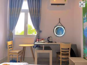 a room with a table and chairs and a mirror at Hotel Phước Thịnh in Vĩnh Long