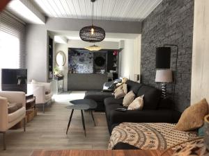 a living room with a couch and a brick wall at Les Platanes in Duingt
