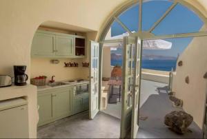una cucina con vista sull'oceano attraverso un arco di Hanging at the top of the world a Oia