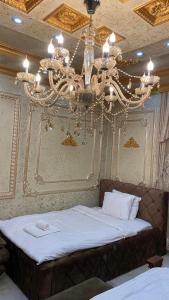 a bedroom with a large bed with a chandelier at Hotel Premium in Pristina