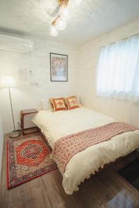 a bedroom with a large bed with a rug at QiQi Serenity Tokyo Exclusive New 3-Story Home, 14min to Skytree, Asakusa Area in Tokyo