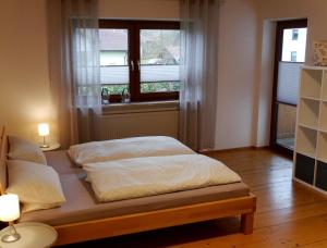 Cama en habitación con ventana y 2 lámparas en Ferienhaus Kirchl, en Hohenau