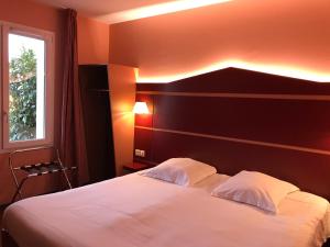 a bedroom with a white bed with a black wall at Fasthotel Montmarault in Montmarault