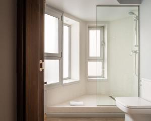 a bathroom with a shower and a toilet and windows at Hotel Madanis Liceo in Hospitalet de Llobregat +27 photos
