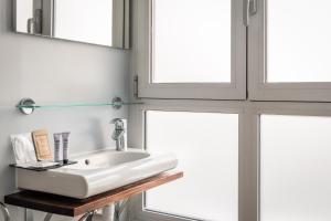a bathroom with a sink and two windows at Hotel Madanis Liceo in Hospitalet de Llobregat