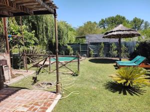 a backyard with a swimming pool and an umbrella at Hanuja Payé in General Belgrano +32 photos