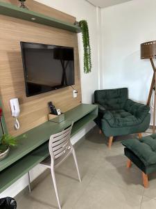 ein Wohnzimmer mit einem Schreibtisch, einem Stuhl und einem TV in der Unterkunft HOTEL TERRA NATIVA in Alter do Chao