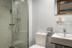 a bathroom with a shower and a toilet and a sink at Hotel Madanis Liceo in Hospitalet de Llobregat