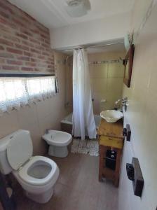 a bathroom with a toilet and a sink and a tub at Hanuja Payé in General Belgrano
