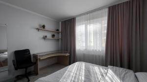 a bedroom with a desk and a bed and a window at Damaris Apartments 2 in Chişinău