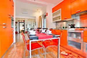 eine Küche mit orangefarbenen Schränken und einem Tisch mit Stühlen in der Unterkunft Terrazza Concordia Amazing View in Neapel