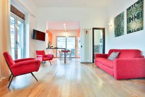 ein Wohnzimmer mit einem roten Sofa und Stühlen in der Unterkunft Terrazza Concordia Amazing View in Neapel