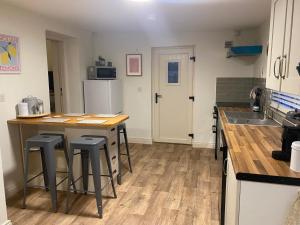 eine Küche mit einer Theke und einigen Barhockern in der Unterkunft Joe’s Cottage in Tynan + 12 Fotos