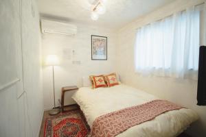 a small bedroom with a bed and a window at QiQi Serenity Tokyo Exclusive New 3-Story Home, 14min to Skytree, Asakusa Area in Tokyo