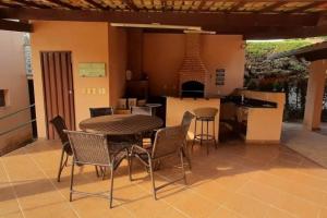 a patio with a table and chairs and a kitchen at Casa confortável em Cond Fechado in Esmeraldas