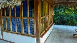 une chambre avec des fenêtres en verre dans une maison dans l'établissement Posada del Cerro, à El Remate