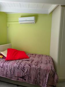 a bedroom with a bed with a red pillow at Strictly-Halaal Holiday Home at Meerensee Resort in Fisherhaven