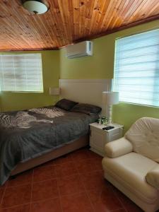 a bedroom with a bed and a couch at Strictly-Halaal Holiday Home at Meerensee Resort in Fisherhaven
