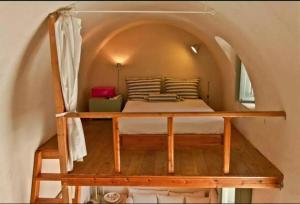 a bed in a small room with an arched ceiling at Hanging at the top of the world in Oia