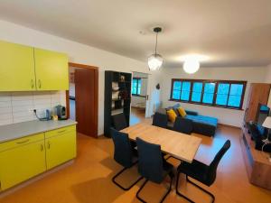 een keuken en een woonkamer met een houten tafel en stoelen bij Industriel F3 Appartement in Thann