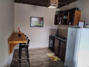 a kitchen with a table and a refrigerator at Flat Raio de Sol - Taipu de Fora in Marau
