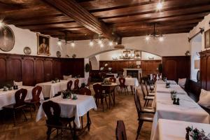 comedor con mesas y sillas blancas y chimenea en Gutshofhotel Winkler Bräu, en Lengenfeld