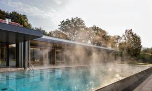 ein Haus mit einem Pool mit Dampf aus ihm heraus in der Unterkunft Gutshofhotel Winkler Bräu in Lengenfeld