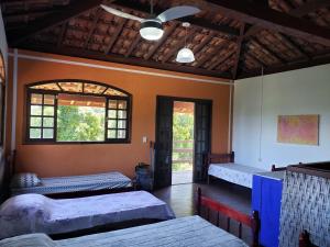 a room with two beds and two windows at Pousada e Hostel Casa da Jura in Ilhabela