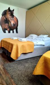 1 dormitorio con 1 cama con una foto de un caballo en la pared en Caballus Lovasmajor en Nyíregyháza