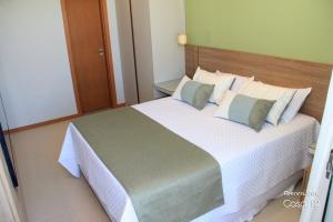 a bedroom with a large bed with white sheets and pillows at Exclusivo 2 suites a Beira Mar Imbassaí Privilege in Imbassai
