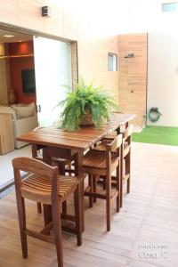 a wooden table and chairs with a plant on it at Exclusivo 2 suites a Beira Mar Imbassaí Privilege in Imbassai