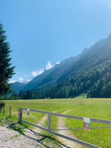 a fence in a field with mountains in the background at Austria Parks - Leutasch in Leutasch +5 photos