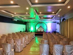 a room with chairs and a stage with green lights at HOTEL NATURE SHIELD in Lonavala